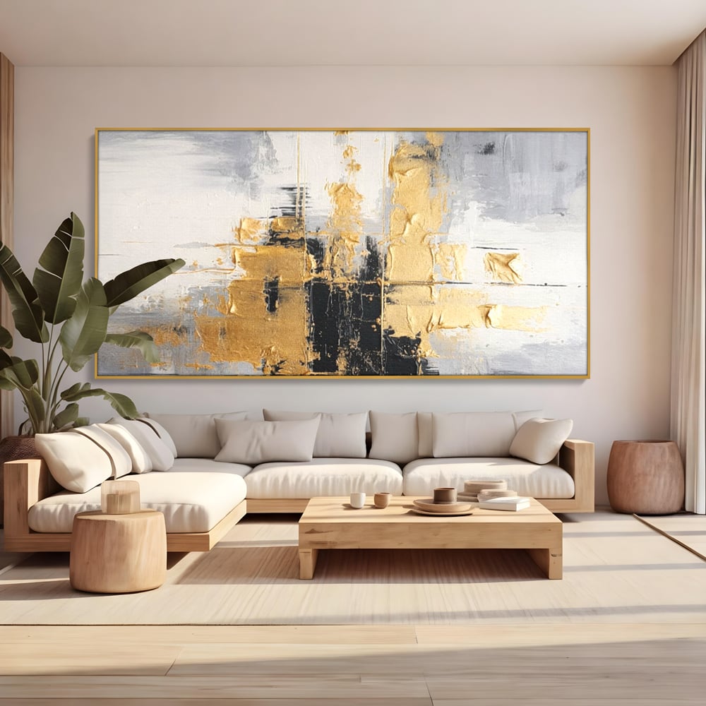 Tablou canvas cu pictura abstracta cu auriu si negru, in rama de aluminiu auriu, pe perete intr-un living